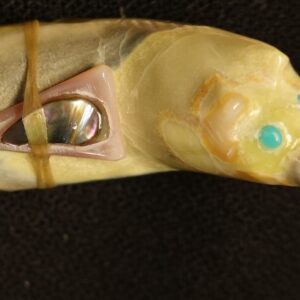Carved animal figurine with turquoise eyes.