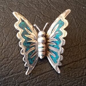 Silver butterfly brooch with blue accents.
