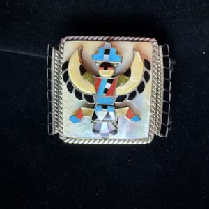 Intricate silver belt buckle with colorful inlays.